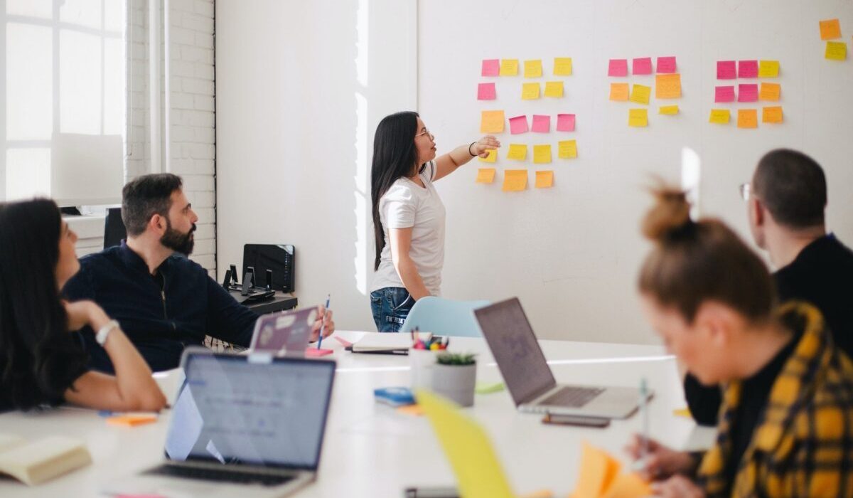 A woman conducts a meeting with colleagues.